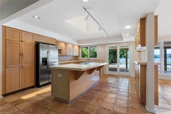 a large kitchen with stainless steel appliances granite countertop a refrigerator and a sink