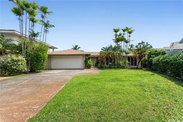 a front view of a house with a yard and a garage