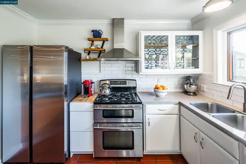 a kitchen with stainless steel appliances granite countertop a stove a refrigerator and a sink