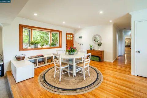 a dining room with furniture a rug and wooden floor