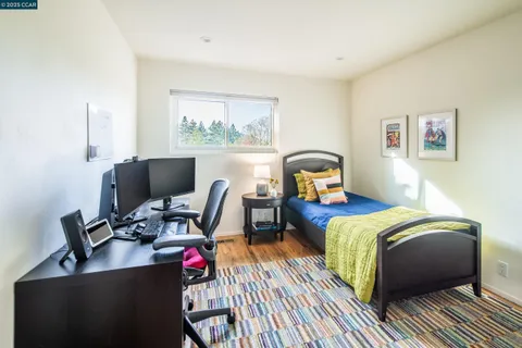 a bedroom with a bed desk and a window