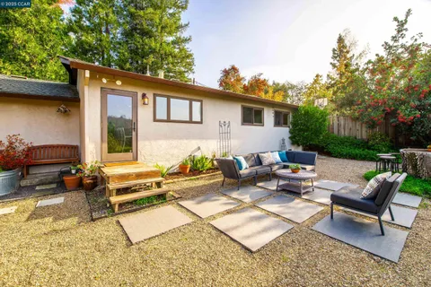 a view of a house with backyard and sitting area