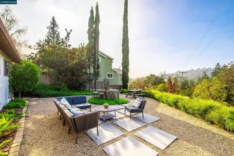 a view of a patio with couches table and chairs next to yard