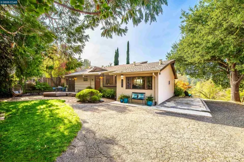 a front view of a house with yard and green space
