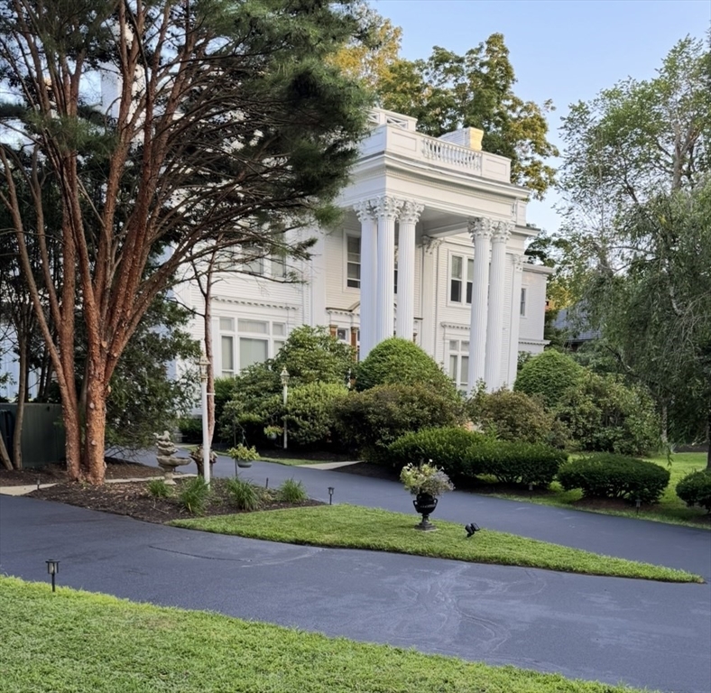 a front view of a house with a yard and potted plants