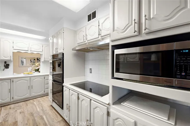 a kitchen with stainless steel appliances white cabinets and a sink