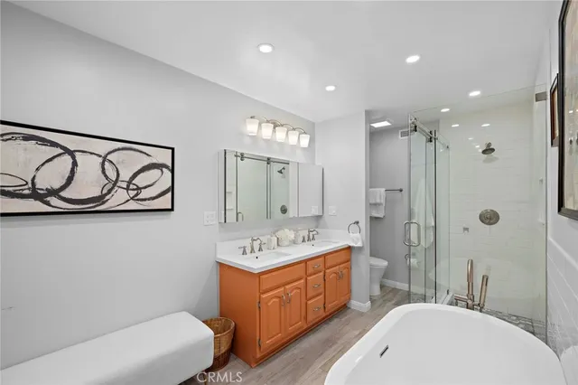 a bathroom with a sink a toilet a mirror and shower