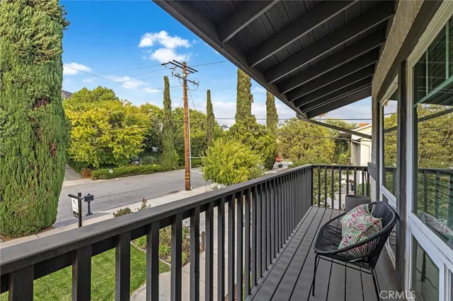 a view of a balcony with couches and wooden floor