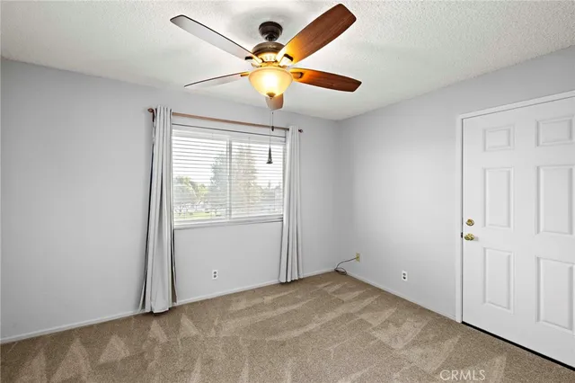 an empty room with chandelier fan
