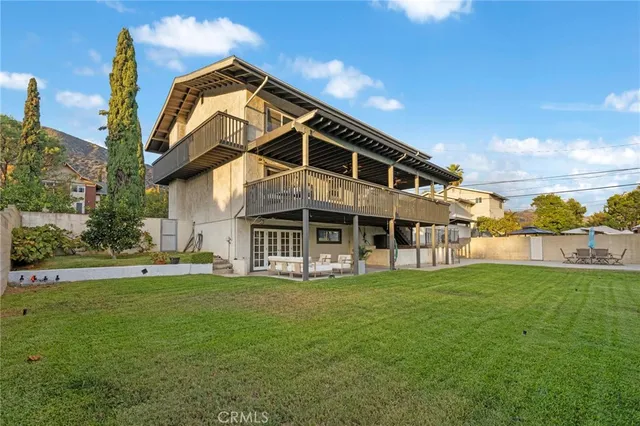 a view of a house with a big yard and large trees