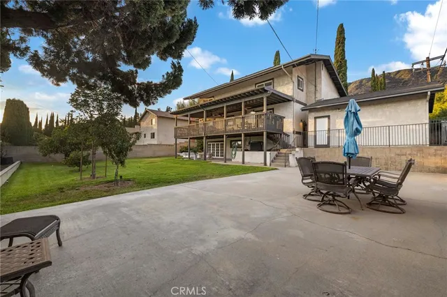 a view of a house with backyard and sitting area
