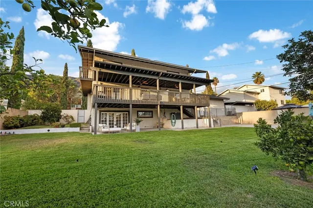 a view of a house with a big yard and large trees