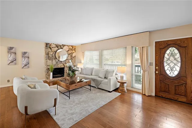 a living room with furniture a fireplace and a table with wooden floor