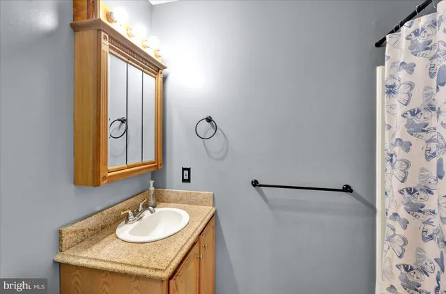 a bathroom with a granite countertop sink and a mirror