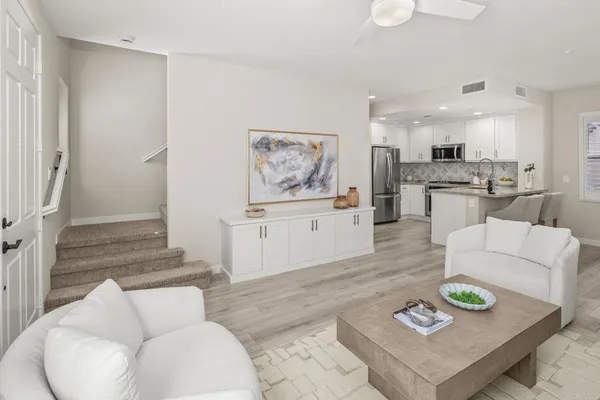 a living room with furniture and a dining table with kitchen view