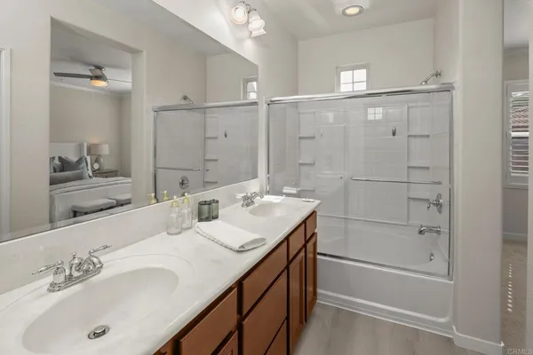 a bathroom with a double vanity sink mirror and shower