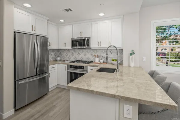 a kitchen with stainless steel appliances granite countertop a refrigerator stove microwave and sink