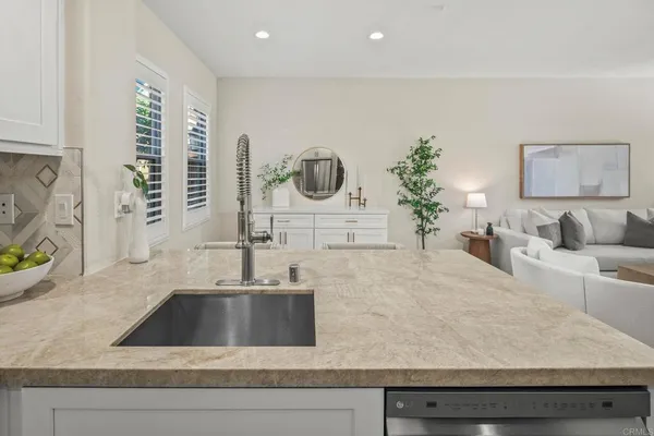 a kitchen with kitchen island a sink a counter top and a potted plant