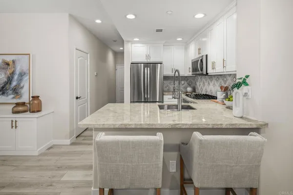 a kitchen with kitchen island granite countertop wooden cabinets and a refrigerator