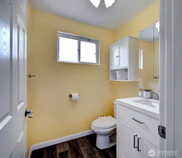 a bathroom with a toilet a sink and mirror