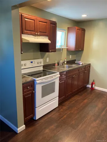 a kitchen with stainless steel appliances a stove and a wooden floors