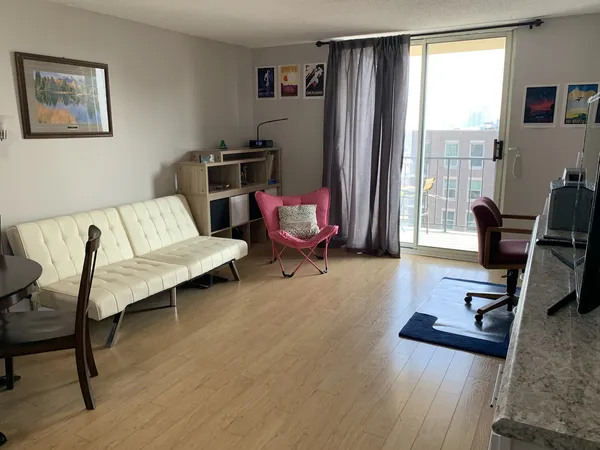 a living room with furniture rug and wooden floor