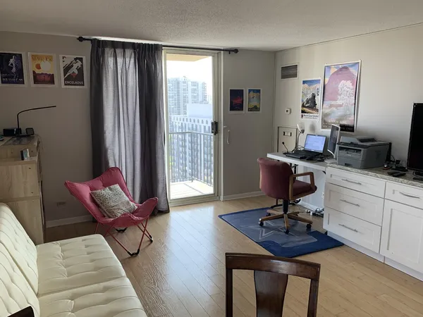 a view of a workspace with furniture and a window