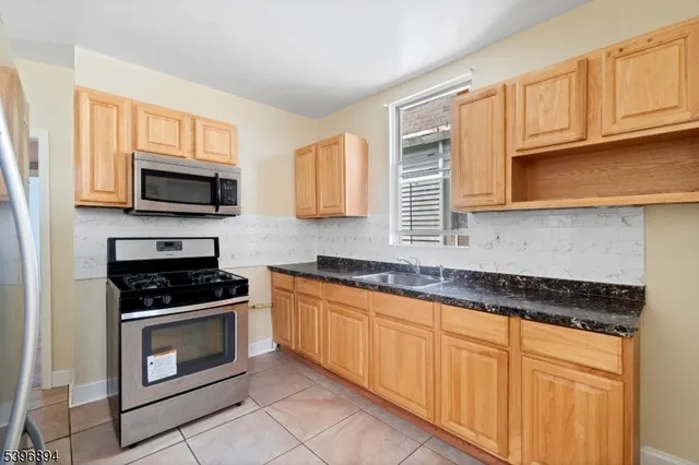 a view of empty room with window and wooden floor