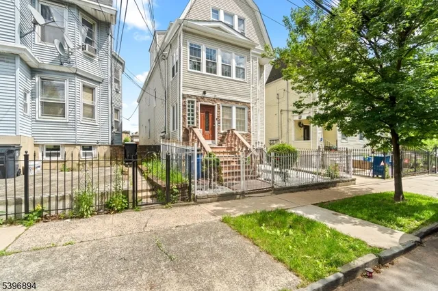 a front view of a house with a garden and plants
