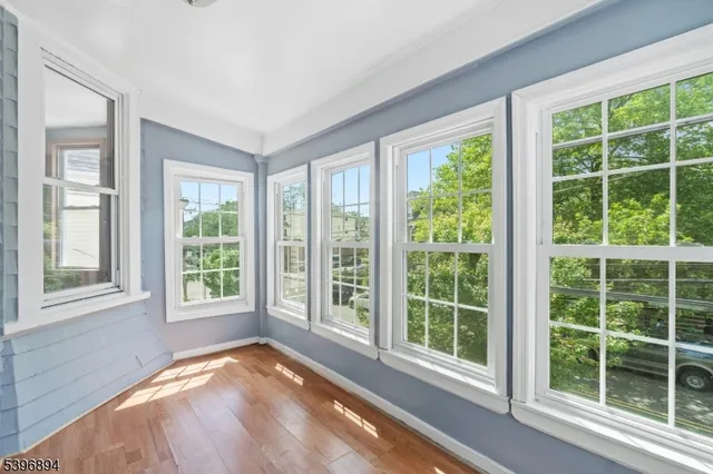 a view of a room that has a bed and wooden floor