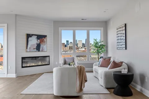 a living room with furniture a fireplace and a large window