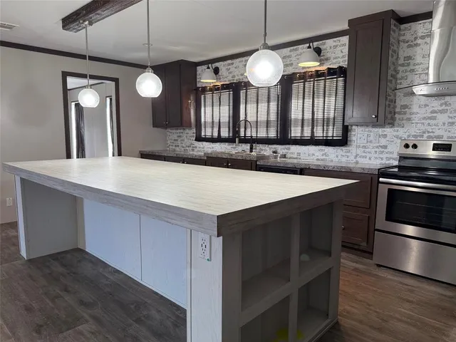 a kitchen with granite countertop stainless steel appliances a refrigerator and cabinets