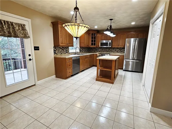 a kitchen with stainless steel appliances a stove a sink dishwasher and a refrigerator