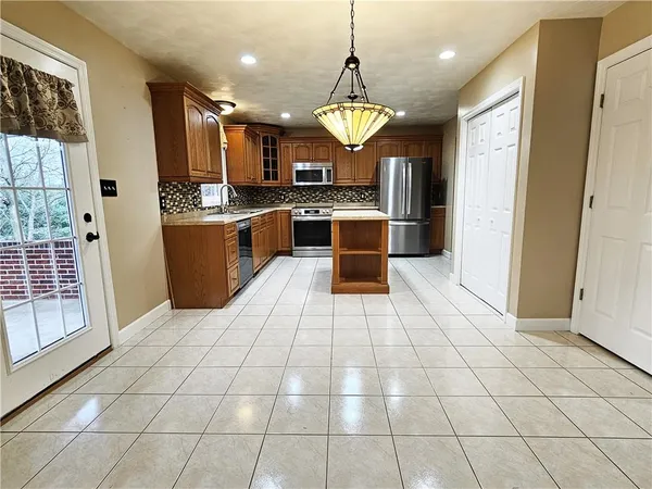 a large kitchen with granite countertop a stove a sink and a refrigerator