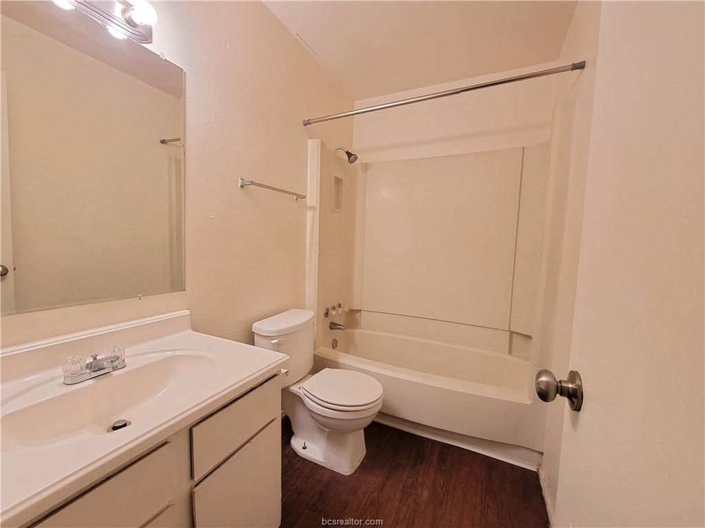 2712 Evergreen Circle Bryan, TX 77801 - Photo 25 of 30 Full bathroom featuring vanity, toilet, hardwood / wood-style floors, and shower combination