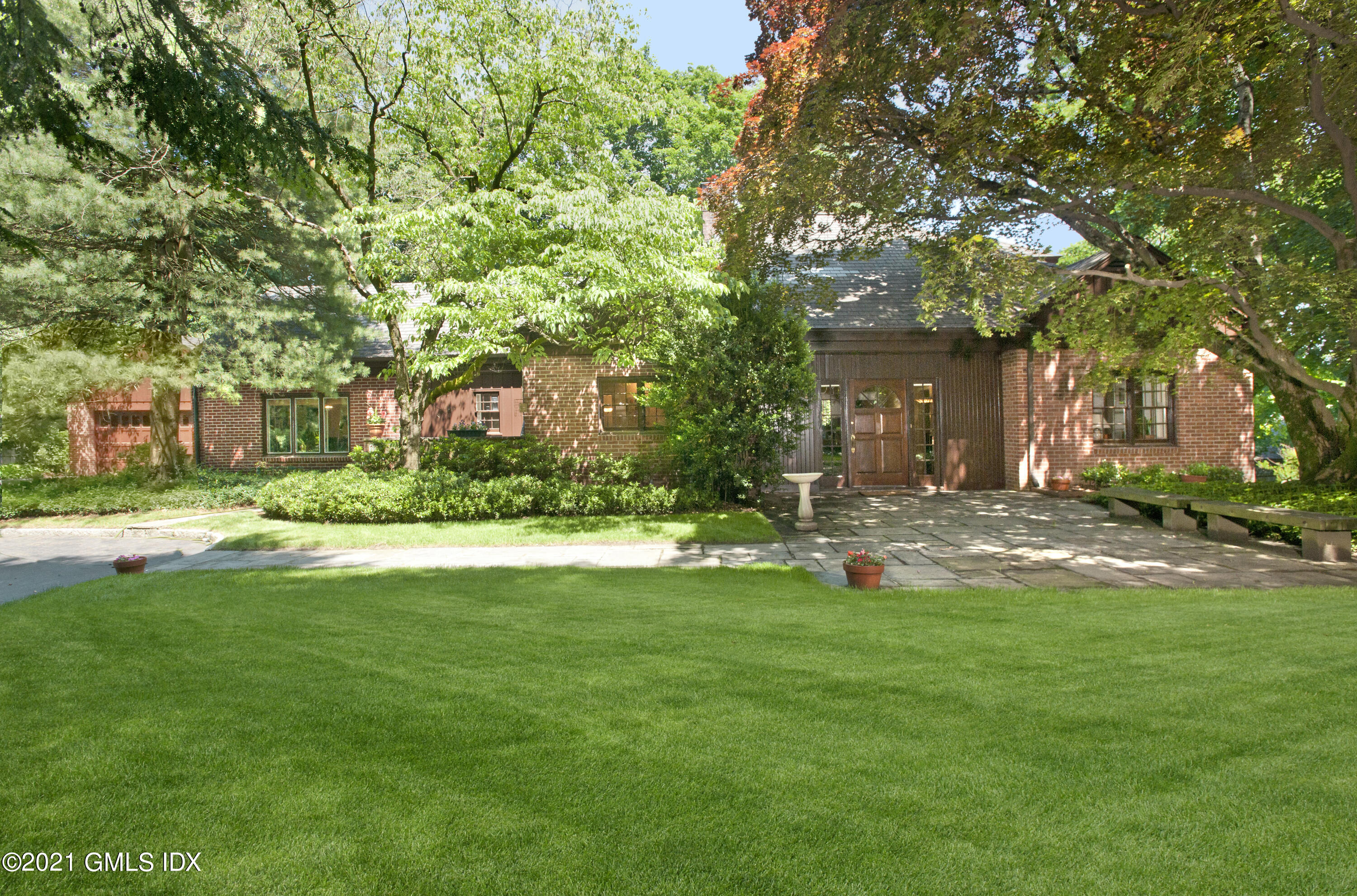 a view of a house with a big yard and large trees
