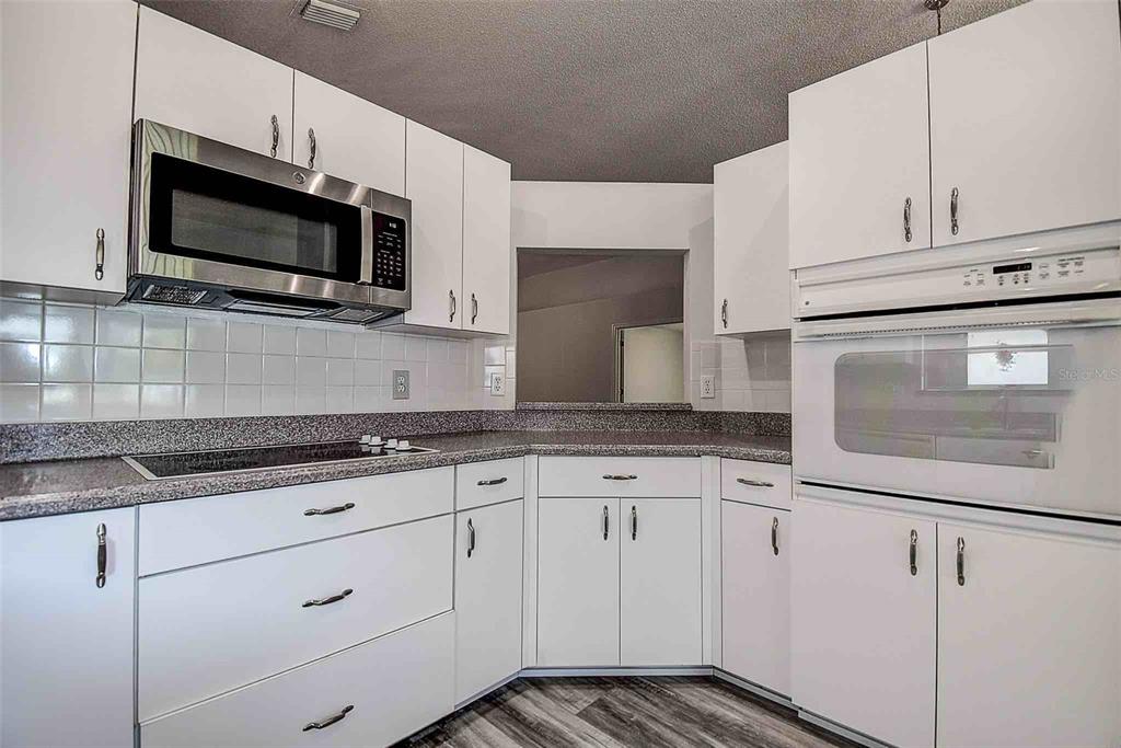 1020 Trafalgar Drive New Port Richey, FL 34655 - Photo 8 of 41 a kitchen with granite countertop white cabinets stainless steel appliances and sink