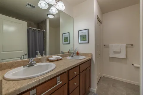 a bathroom with a granite countertop sink a large mirror and a toilet