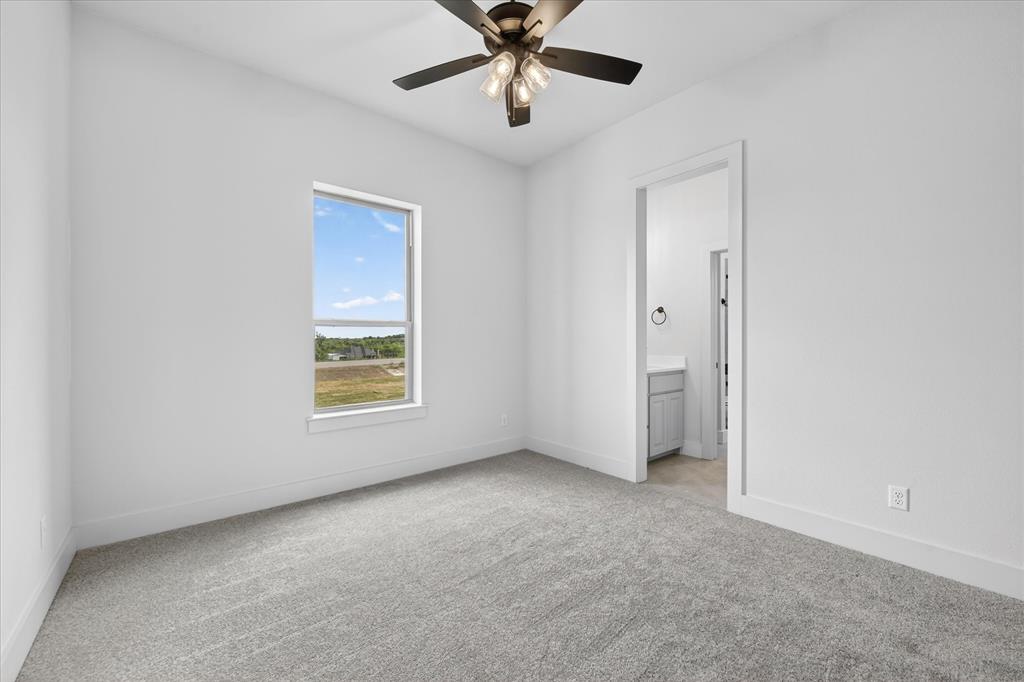517 Longhorn Lane Springtown, TX 76082 - Photo 29 of 39 Unfurnished bedroom featuring light colored carpet, a ceiling fan, and ensuite bathroom