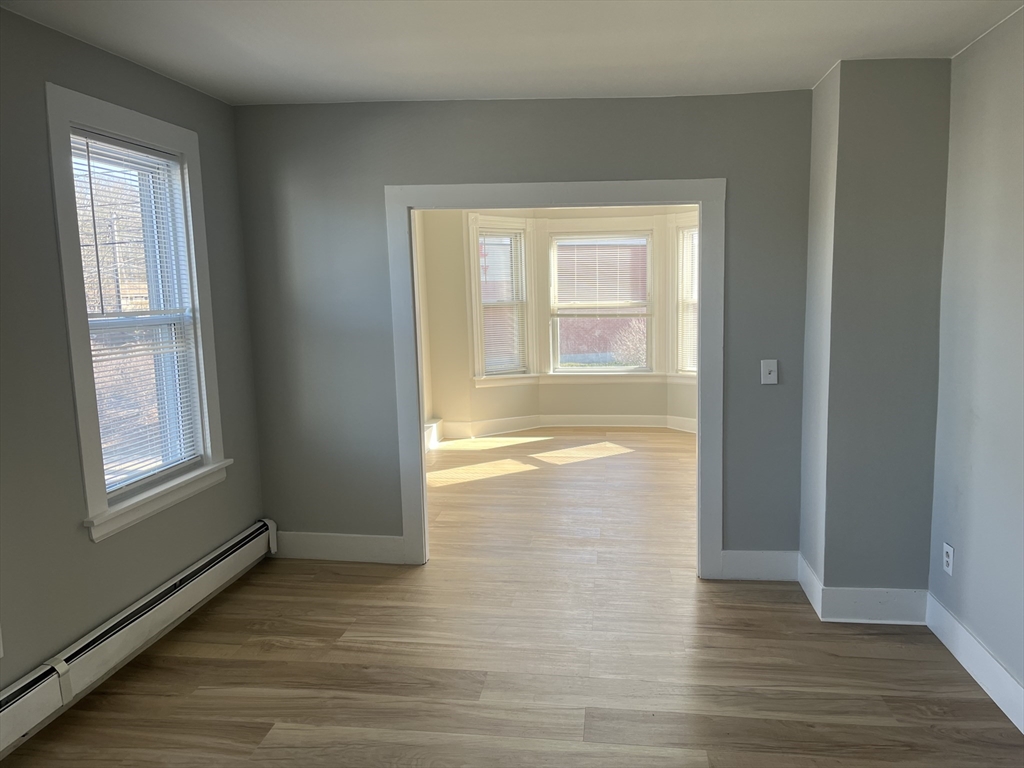159 East Central Street, Unit 2 Franklin, MA 02038 - Photo 12 of 28 a view of an empty room with wooden floor and a window