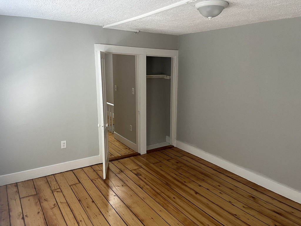 159 East Central Street, Unit 2 Franklin, MA 02038 - Photo 23 of 28 a view of an empty room with wooden floor and a window
