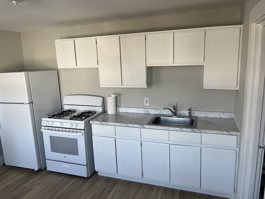 159 East Central Street, Unit 2 Franklin, MA 02038 - Photo 8 of 28 a kitchen with sink a stove and cabinets