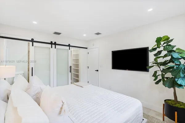 a bedroom with a bed and a potted plant