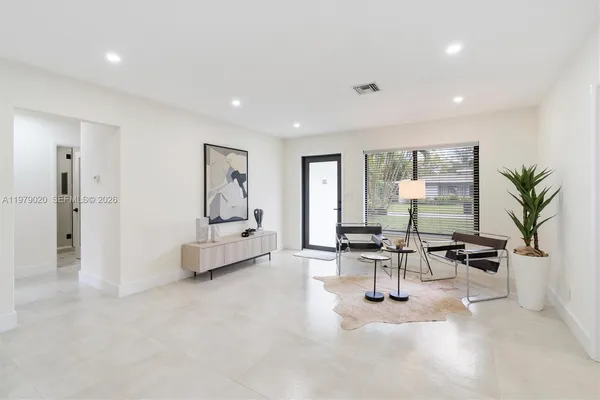 a living room with furniture and large windows