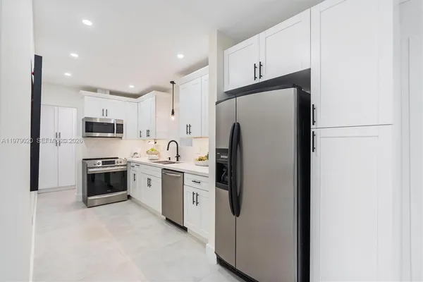 a kitchen with stainless steel appliances a refrigerator stove and microwave