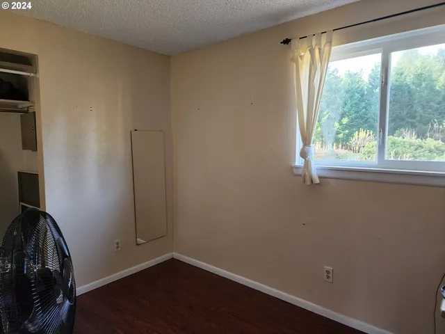 a view of a room with wooden floor and a window