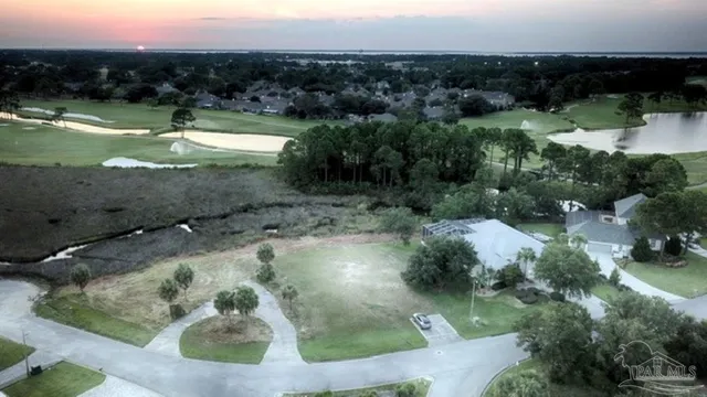 an aerial view of a house with a yard and lake view