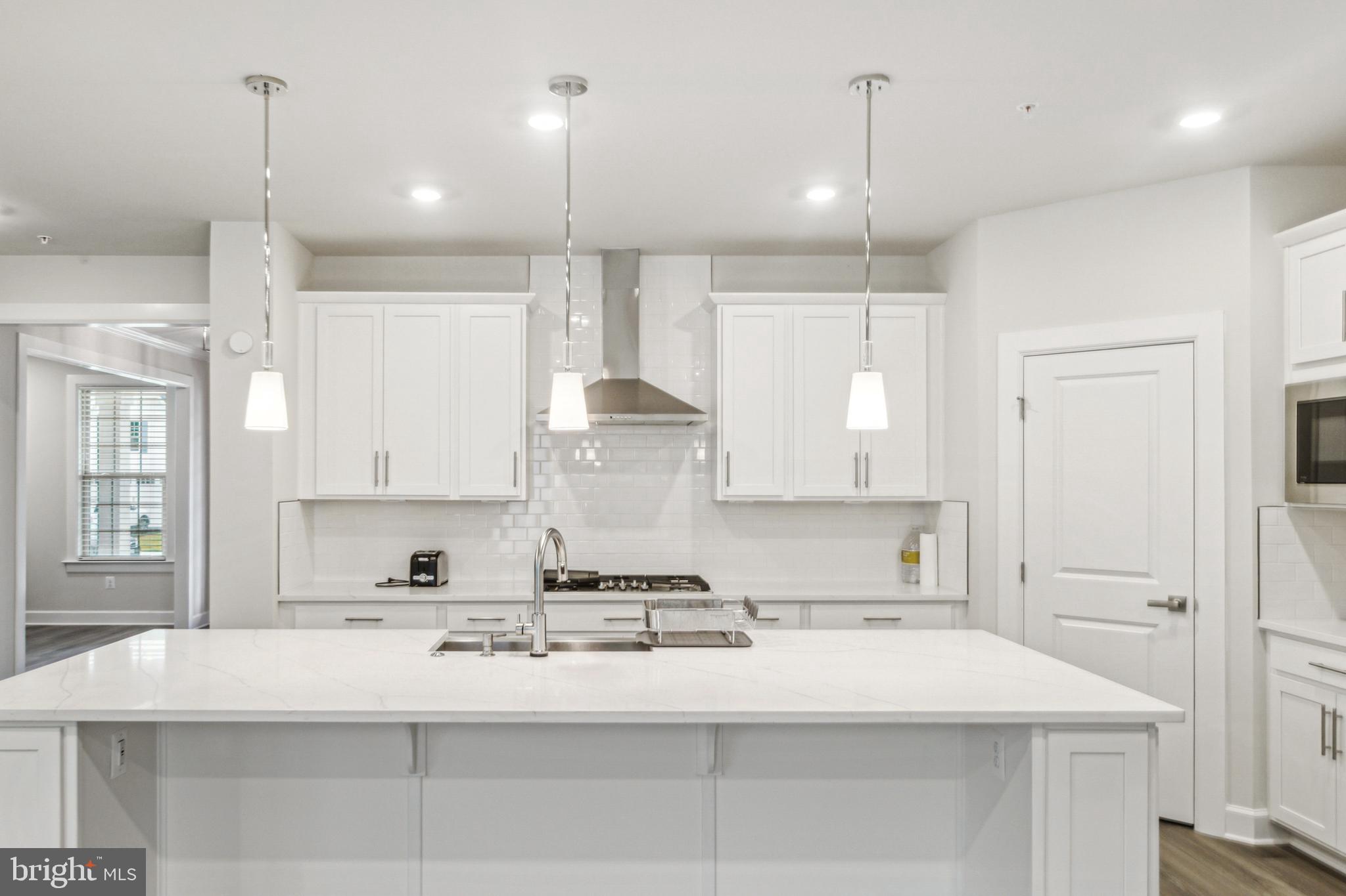 6536 Clubhouse Drive Laurel, MD 20708 - Photo 12 of 40 a kitchen with kitchen island a counter top space a sink stainless steel appliances and cabinets