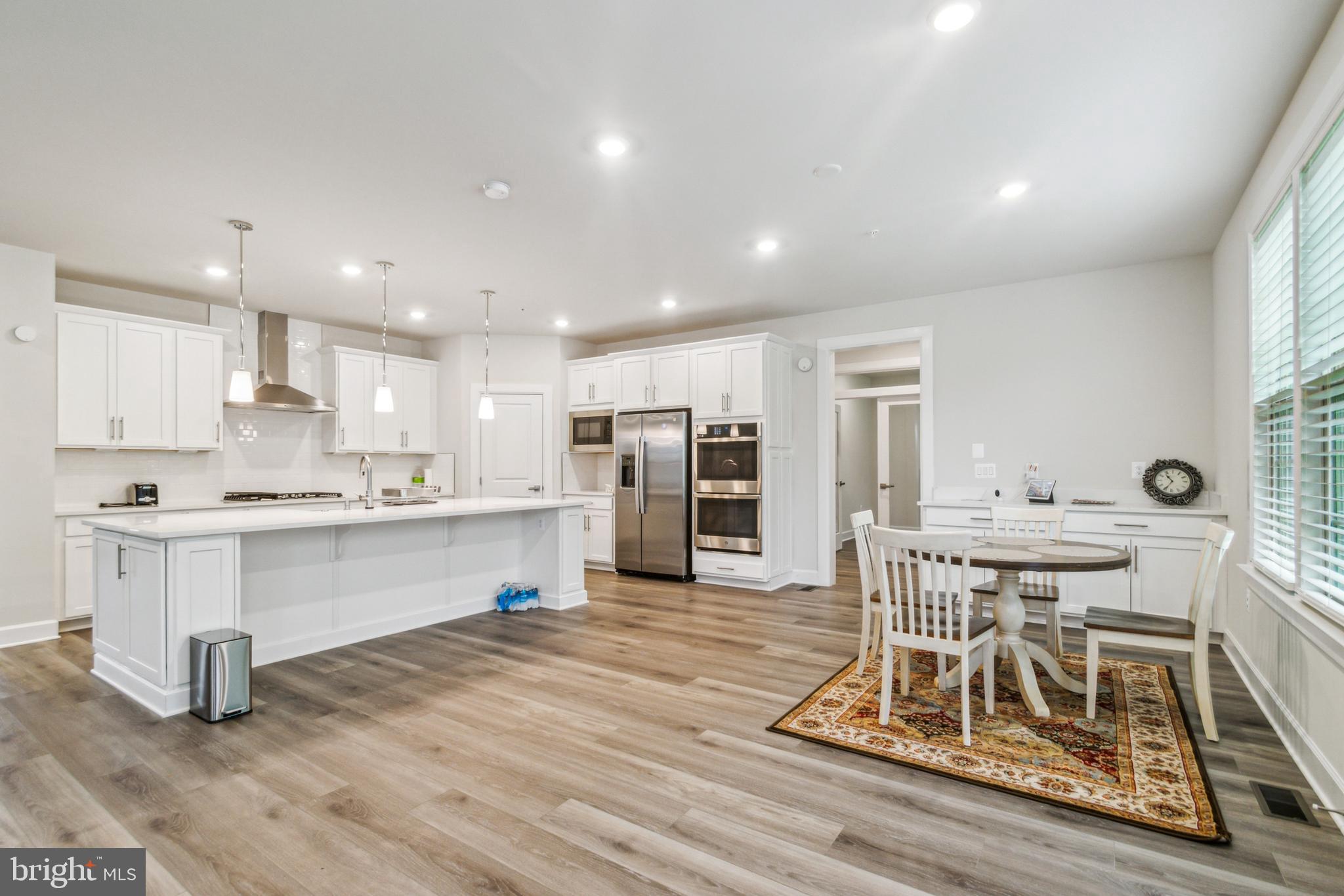 6536 Clubhouse Drive Laurel, MD 20708 - Photo 16 of 40 a large dining hall with stainless steel appliances wooden floors and wooden cabinets