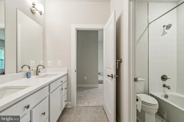 a bathroom with a double vanity sink toilet mirror and shower